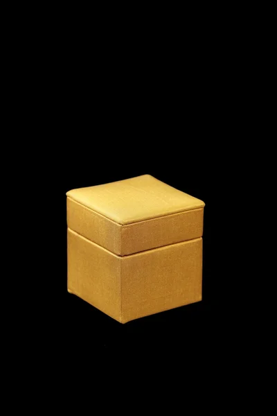 Caixa de seda amarela no fundo escuro — Fotografia de Stock