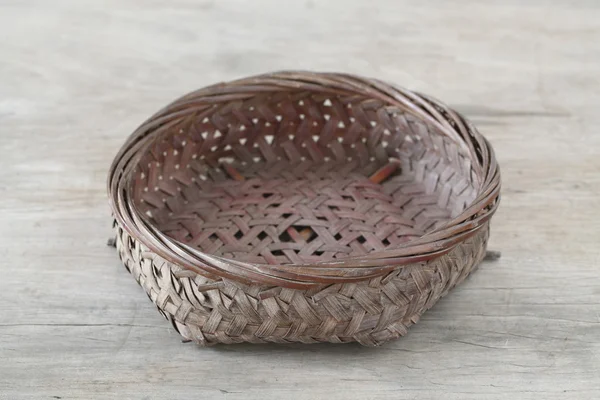 Flat basket on wooden table — Stock Photo, Image