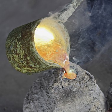 Pouring liquid bronze in mold clipart