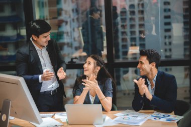 İş dünyası yaratıcıları, pazarlama planı fikri tartışması için ofiste toplanıyorlar.