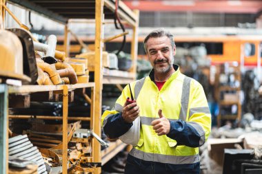Güvenlik kasketli profesyonel teknisyen. Endüstriyel fabrikada inşaat malzemelerinin bakımında çalışıyor. Teftiş görevlisi üretim teknolojisi işiyle uğraşıyor.