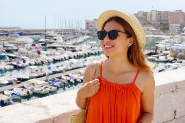 Bisceglie Limanı, Apulia, İtalya 'da turuncu elbiseli neşeli bir kadının portresi.