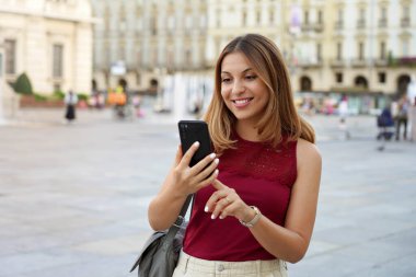 Video çağrısı ya da kentsel geçmişi bulanık sosyal ağ için aygıt kullanan çekici çok ırklı genç kadın