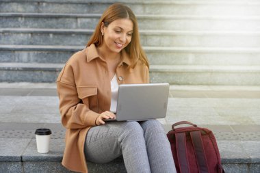 Genç bir girişimci. Üniversite öğrencisi. Dizüstü bilgisayarla çalışıyorum. Bilgisayar ağı. Dışarıda oturuyordum. Yurtdışında okuyun. Kahve fincanı..