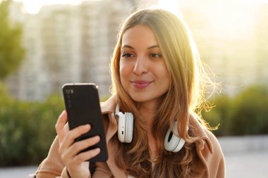 Modern milenyum, akıllı telefonundan gün batımında kulaklıkla dinlemeye kadar bir şarkı seçiyor.