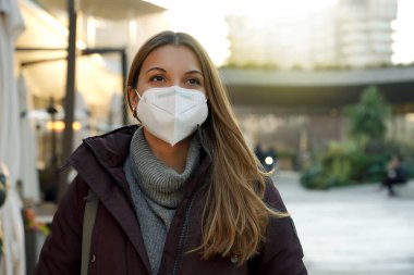 Şehirde tıbbi maske takan genç bir kadının portresi virüse karşı korunma amaçlı.