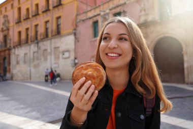 Murcia, İspanya 'da sokak yemekleri. İspanya Murcia caddesinde pastel de carne murciano (Murcia köftesi) tutan güzel bir turist kız..