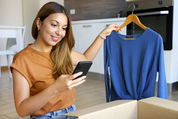 小企业主 时尚的小企业主女人用智能手机应用程序在网上销售服装 — 图库照片
