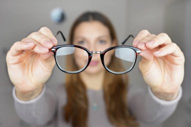 Kötü görüş konsepti. Kız elinde gözlük tutuyor..