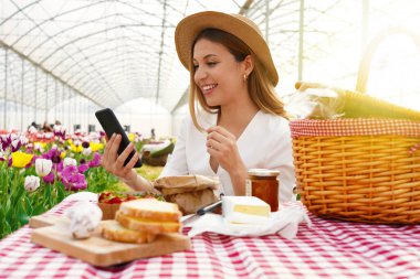 Teknoloji ve yaşam tarzı konsepti. Piknik deneyimini arkadaşlarıyla internet üzerinden paylaşan bir kız.