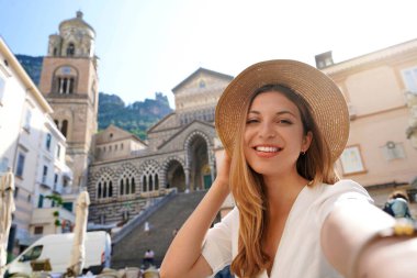 Amalfi, Amalfi Sahili, İtalya 'da kameraya gülümseyen mutlu genç ve güzel bir turist kız selfie çekiyor.