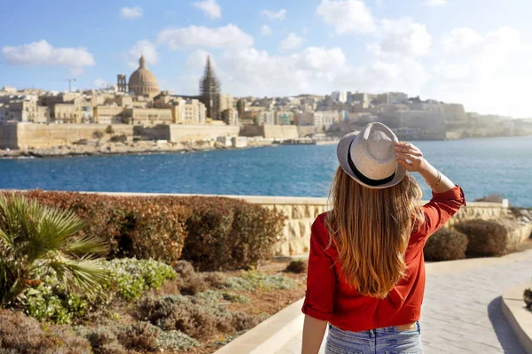 一位戴着帽子的年轻貌美的女士沿着马耳他海滨俯瞰着马耳他瓦莱塔美丽的全景 — 图库照片