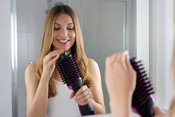 Pleased Girl Holds Brush Hair Dryer Her Bathroom Home Young — Stock Photo, Image