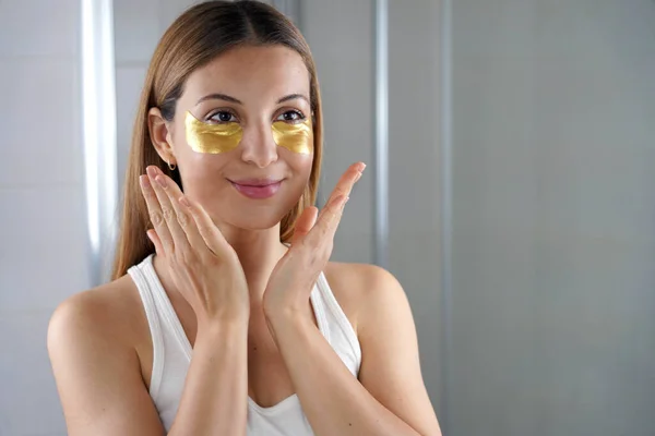Beauty Girl Applying Golden Aging Eye Mask Looking Herself Mirror — ストック写真