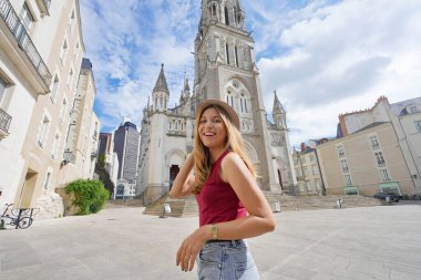 Fransa 'nın Nantes şehrini ziyaret eden gülümseyen turist kız. Kameraya bakar. Geniş açı.