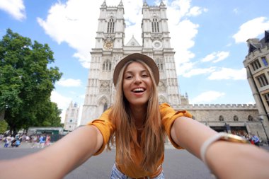 Londra 'da Westminster Abbey Gotik Kilisesi' nde selfie çeken genç gezgin kız. Genç bir kadın Londra, İngiltere 'de tatilde..