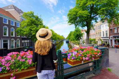 Hollanda, Lahey 'deki çiçek saksıları arasındaki genç turist kadın.