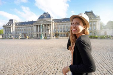 Portrait of young tourist woman visiting on sunset the Royal Palace of Brussels, Belgium