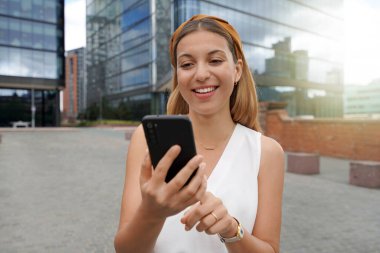 Beautiful business woman using mobile phone outdoors. People communication technology concept.