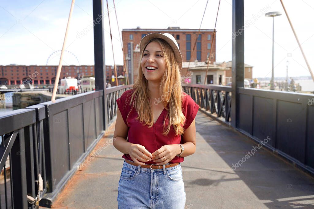 Attractive fashion girl walking on Swing Bridge in Royal Albert Dock, Liverpool, UK