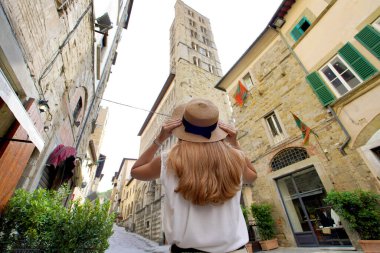 Orta çağ kasabası Arezzo, Tuscany, İtalya 'da yürüyen güzel bir turist kızı. Düşük açı.