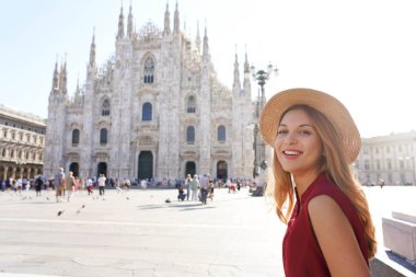 İtalya 'da turizm. İtalya 'nın arka planında Milan Katedrali' nin yanında oturan güzel, gülümseyen kız..