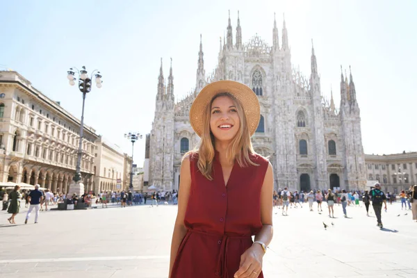 Milan modası. Genç ve şık bir kadın güneşli bir günde ana meydanda gülümsüyor..