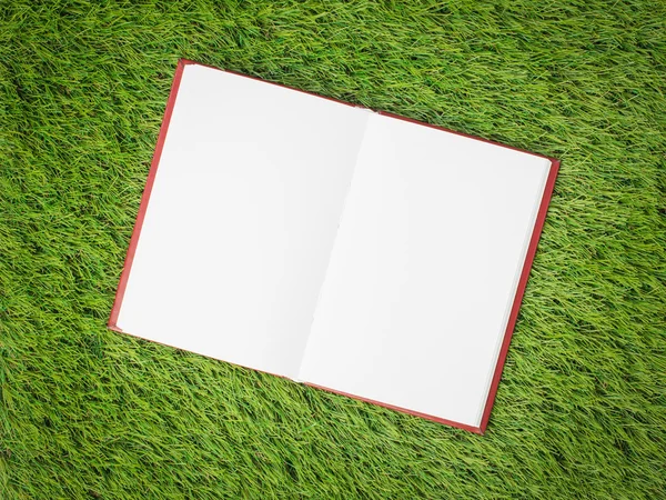 Open boek met blanke pagina op groene kunstgras — Stockfoto