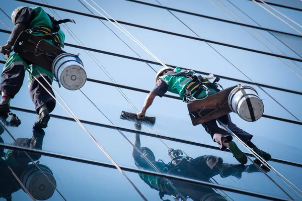 Grupo de trabalhadores serviço de limpeza de janelas em edifício alto — Fotografia de Stock