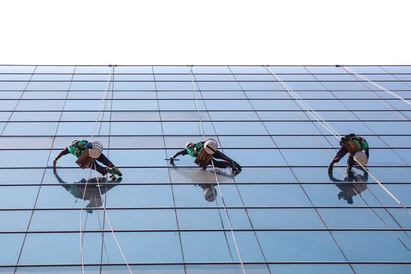 Gruppe af arbejdstagere rengøring vinduer service på højhus bygning - Stock-foto