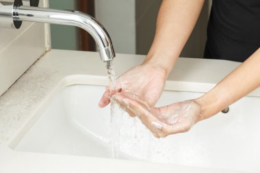 Ellerimi sabunla yıkıyorum.