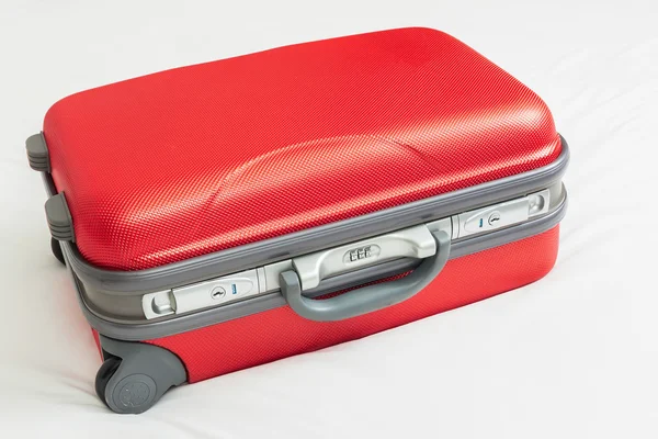 Business suitcase, red color on bed for traveling — Stock Photo, Image