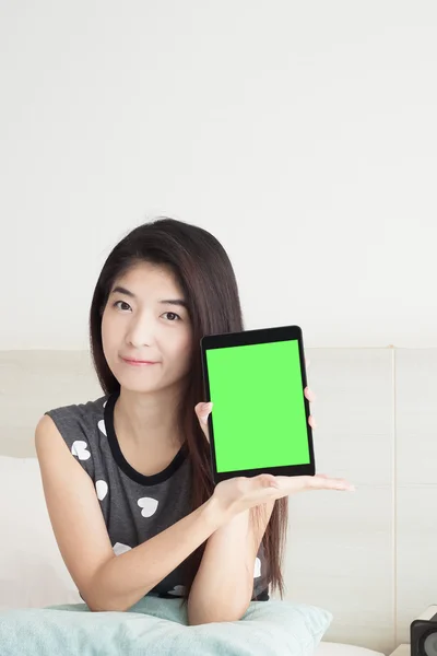 Junge asiatische Frau zeigt oder zeigt Tablet mit grünem Bildschirm — Stockfoto