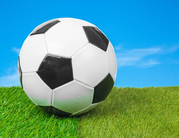 Футбольный мяч на поле и голубое небо — стоковое фото