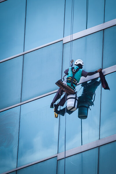group of workers cleaning windows service on high rise building