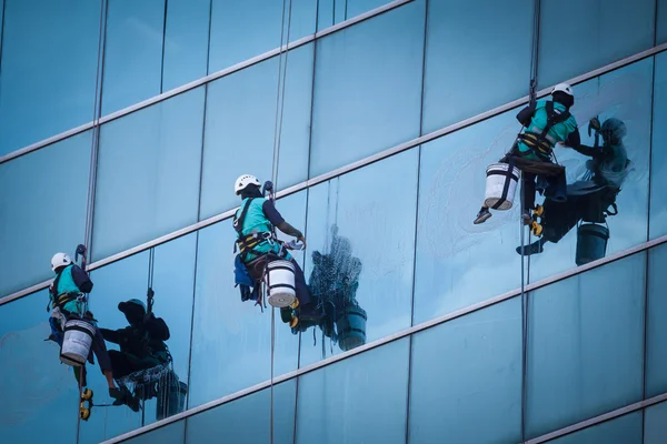 高层建筑物清洗窗户的一组工人 — 图库照片
