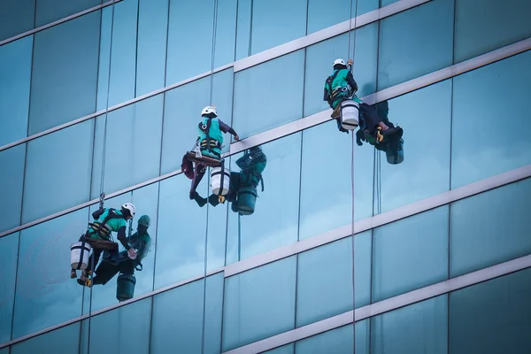 Grupo de trabajadores servicio de limpieza de ventanas en edificio de gran altura — Foto de Stock