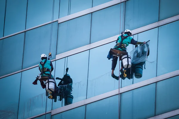 Grupo de trabajadores servicio de limpieza de ventanas en edificio de gran altura — Foto de Stock