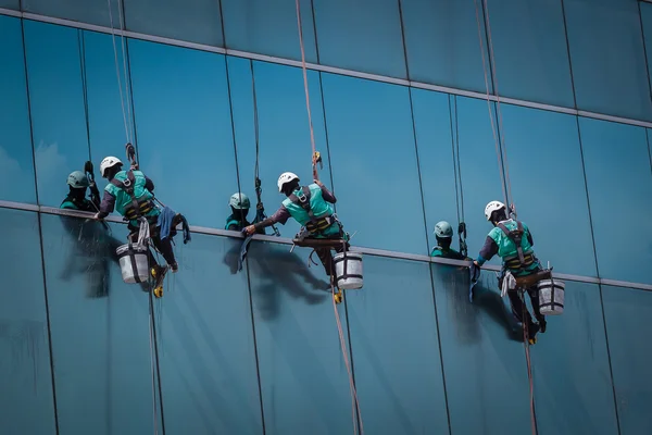 Groep werknemers die ramen schoonmaken op hoogbouw — Stockfoto