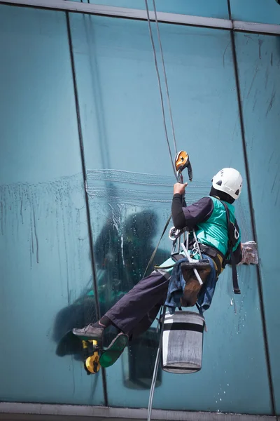 Grupo de trabalhadores serviço de limpeza de janelas em edifício alto — Fotografia de Stock