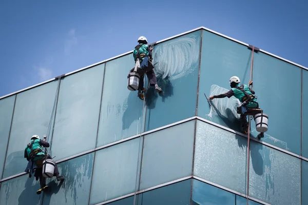Grupp arbetstagare rengöring fönster service på höghus byggnad — Stockfoto