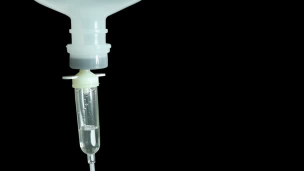 Infusionsflasche mit Kochsalzlösung für Patienten auf schwarzem Hintergrund — Stockvideo