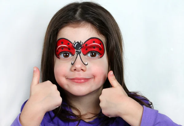 Hübsches Mädchen mit Kinderschminken eines Marienkäfers. — Stockfoto