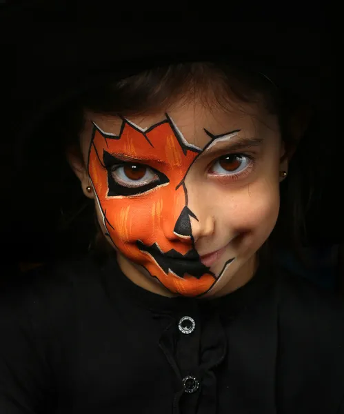 Pretty girl with face painting of a pumpkin — Stock Photo, Image