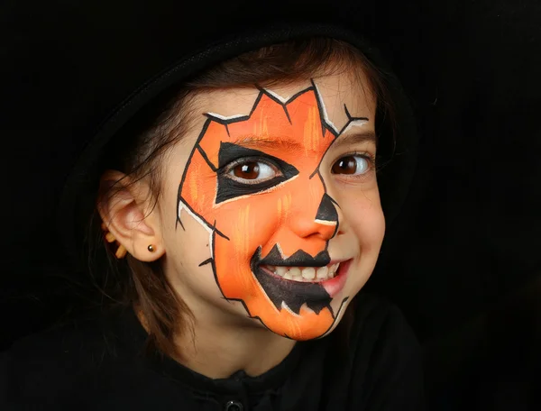 Bella ragazza con la pittura facciale di una zucca — Foto Stock