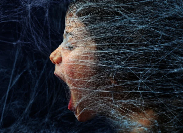 Garota assustada presa em uma teia de aranha — Fotografia de Stock