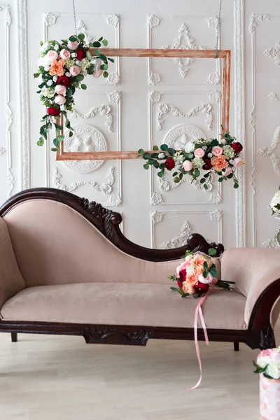 Kadifelerden yapılmış kanepe, bitki temalı beyaz bir sıva duvarının arka planında