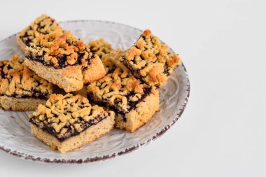 Beyaz tabakta reçelli kare kurabiyeler. Sol tarafında kurabiyeler olan beyaz tabak. Metin için yer