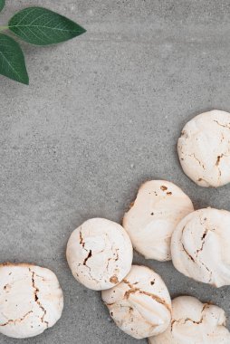 Mutfak masasında krema var. Sağ alttaki kremalı pasta. Gri arka planda kremalı pasta. Mesaj için yer. Masada yeşil bir dal var..