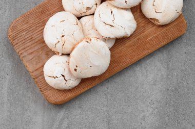 Tahta kesme tahtasında bir sürü krema var. Kakaodan kremalı pasta. Gri arkaplanda krema.